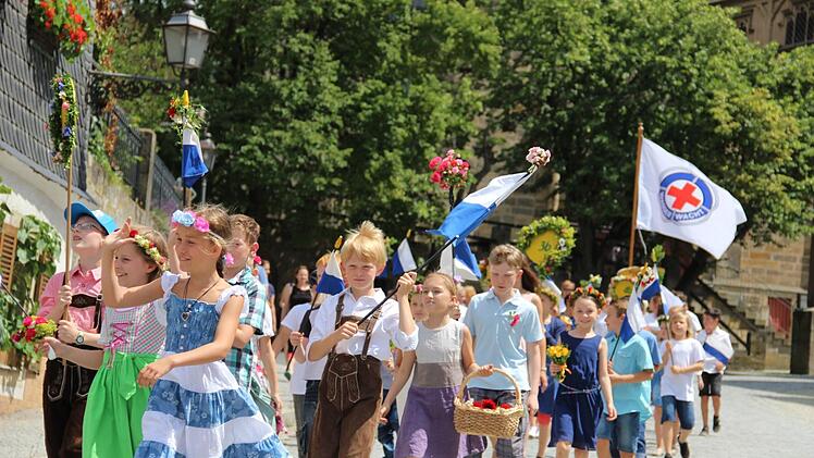 Freudig laufen die Kinder durch die Straßen und winken den Zuschauern zu. Foto: Katharina Müller-Sanke