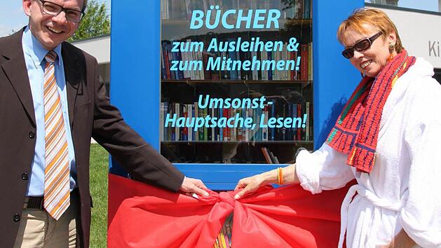 B&uuml;rgermeister Armin Warmuth und die Leiterin der Stadtbibliothek Karin Wengerter er&ouml;ffneten die B&uuml;cherei in der Telefonzelle. Foto: Markus Reeh
