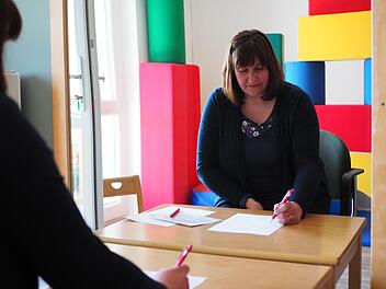 Ergotherapeutin Eileen Ahnemüller zeigt eine Übung, bei der eine Form nur mit dem Blick in den Spiegel nachgezeichnet wird.