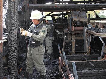 Brandermittler der Bayreuther Kriminalpolizei nehmen den Brandort im Sägewerk in Marktschorgast unter die Lupe. Foto: Stephan Tiroch