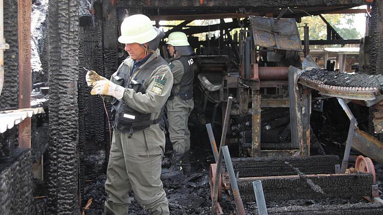 Brandermittler der Bayreuther Kriminalpolizei nehmen den Brandort im Sägewerk in Marktschorgast unter die Lupe. Foto: Stephan Tiroch