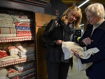 Bett- und Tischwäsche hat Gudrun Zwingelberg beigesteuert. Sie zeigt Ulrike Gunsenheimer das feine Leinen in Waffelmuster. Foto: Gabi Bertram
