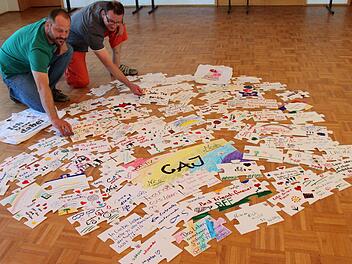 Andreas Hummel (l.) und Stefan Kirchner legen die Puzzle-Teile aus, die in Adelsdorf schon gestaltet wurden. Foto: Johanna Blum