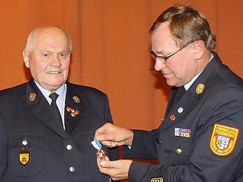 Kreisbrandrat Benno Metz heftet Herbert Nürnberger das Bayerische Feuerwehr-Ehrenkreuz in Silber an. Fotos: Björn Hein