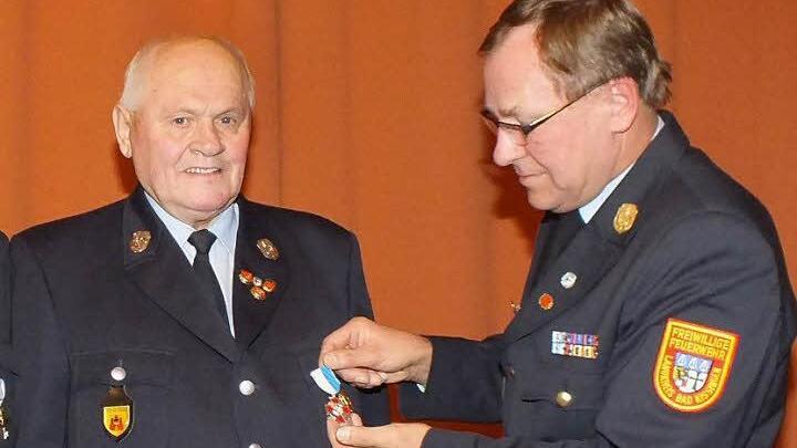 Kreisbrandrat Benno Metz heftet Herbert Nürnberger das Bayerische Feuerwehr-Ehrenkreuz in Silber an. Fotos: Björn Hein
