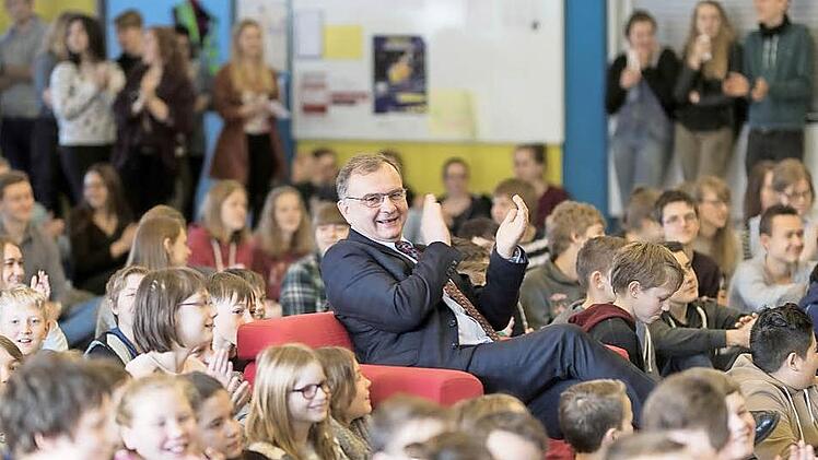 Auf dem Chefsessel erst Platz genommen, dann geräumt: Klauspeter Schmidt inmitten seiner Schüler, für die er auch bei seiner Verabschiedung ein offenes Ohr hatte. Fotos: RudiHein/Ralf Kestel