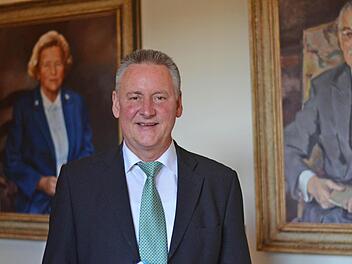 Oberbürgermeister Thomas Jung vor den Bildern von Quelle-Gründer Gustav Schickedanz und seiner Frau Grete im Fürther Rathaus.  Foto: Nikolas Pelke