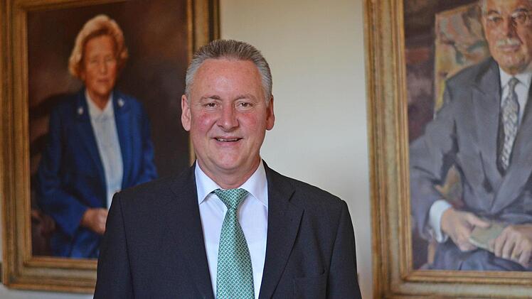 Oberbürgermeister Thomas Jung vor den Bildern von Quelle-Gründer Gustav Schickedanz und seiner Frau Grete im Fürther Rathaus.  Foto: Nikolas Pelke