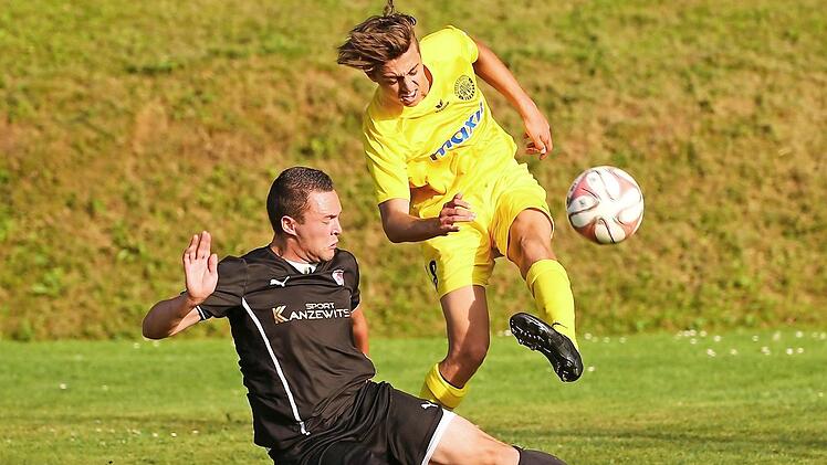 An der Außenlinie rutscht der Kronacher Philipp Krauß in den Flankenball von David Lanlois und blockt ihn erfolgreich.