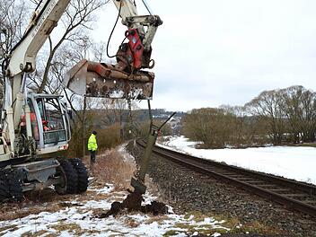Der Bagger reißt am Bahnübergang "Auweg" zwischen Trebgast und Schlömen die Schrankenpfosten aus dem Boden. Auf der rechten Seite neben den Bahngleisen ist der Weg zu erkennen, den die Landwirte jetzt nutzen und den die Gemeinde für Radler ausbauen will. Foto: Dieter Hübner