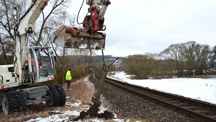 Der Bagger reißt am Bahnübergang "Auweg" zwischen Trebgast und Schlömen die Schrankenpfosten aus dem Boden. Auf der rechten Seite neben den Bahngleisen ist der Weg zu erkennen, den die Landwirte jetzt nutzen und den die Gemeinde für Radler ausbauen will. Foto: Dieter Hübner