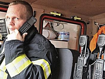Mit der neuen Technik: Sven Kuhn, der Zweite Kommandant der Feuerwehr in Unterpreppach, zeigt die neuen digitalen Funkgeräte. Er hat das fest eingebaute Teil am Ohr, und rechts sind zwei neue Handfunkgeräte zu sehen.  Foto: Helmut Will