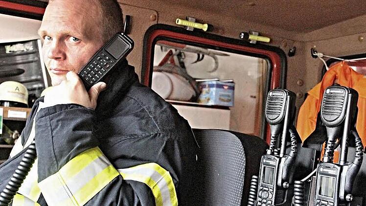 Mit der neuen Technik: Sven Kuhn, der Zweite Kommandant der Feuerwehr in Unterpreppach, zeigt die neuen digitalen Funkgeräte. Er hat das fest eingebaute Teil am Ohr, und rechts sind zwei neue Handfunkgeräte zu sehen.  Foto: Helmut Will