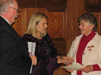 Adelheid Ramming (rechts) erhält von Staatssekretärin Melanie Huml das Verdienstkreuz samt Urkunde überreicht. Links im Bild Regierungspräsident Wilhelm Wenning. Foto: privat