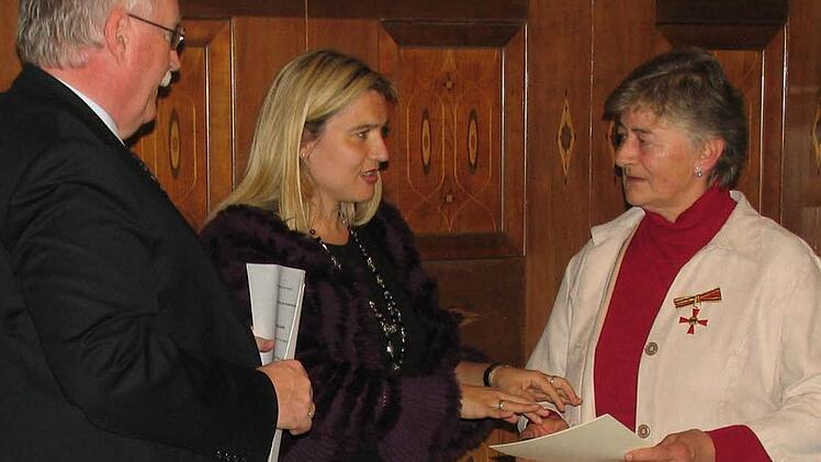Adelheid Ramming (rechts) erhält von Staatssekretärin Melanie Huml das Verdienstkreuz samt Urkunde überreicht. Links im Bild Regierungspräsident Wilhelm Wenning. Foto: privat