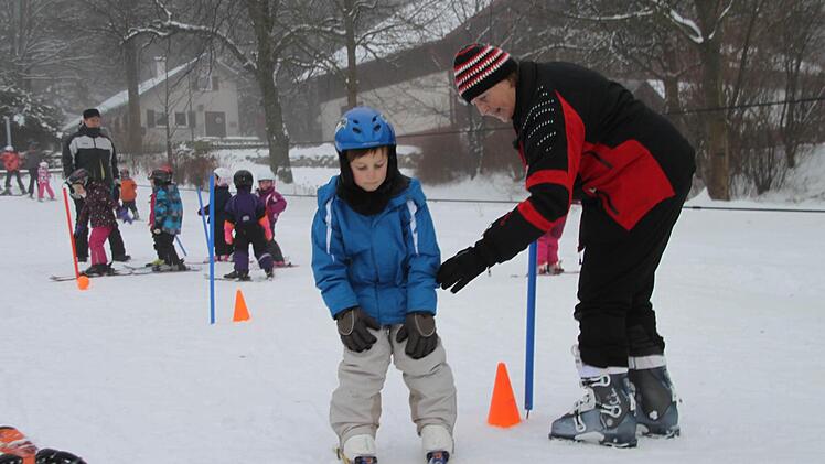 "Prima gemacht". Die Skilehrerin lobt den Jungen, der seine ersten Übungen macht.