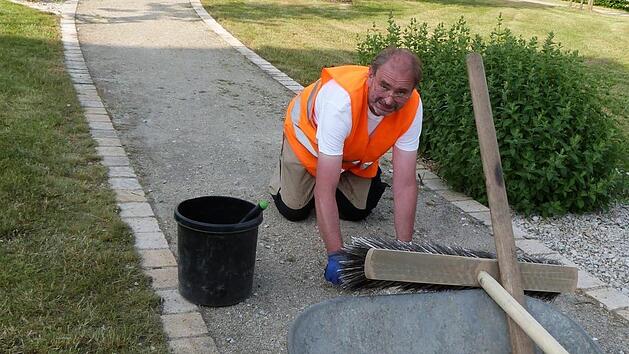 Eddi Grimm bei seiner t&auml;glichen Arbeit. Kniend zupft der "Mister Saubermann" das Unkraut aus den Wegen des Partnerschaftsplatzes heraus. Foto: Werner Rei&szlig;aus