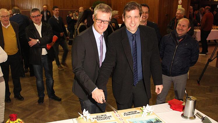 Landrat Hermann Ulm (rechts) und Oberbürgermeister Uwe Kirschstein schneiden zur Feier des Tages die "Hochzeitstorte" an. Foto: Holger Strehl, Landkreis Forchheim