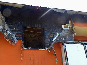 Der Wärmeschutz vom Mauerwerk gelöst, das Fenster nicht mehr vorhanden und die Innen-Wände gezeichnet von Brand und Ruß:  einen Tag nach dem Wohnungsbrand in Oerlenbach untersuchten die Polizei und die Hausverwaltung den Brandort. Foto: Hans-Peter...