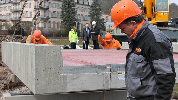 Milimeterarbeit: Polier Rainer Lang (ganz links) und sein Team senken den 12 Tonnen schweren Überbau auf das Fundament ab. Fotos: Benedikt Borst