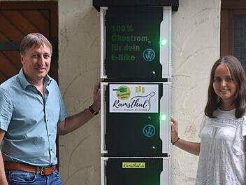 Bürgermeister Rainer Morper nimmt mit Projektmanagerin Saskia Bleher von Naturstrom die E-Bike Ladestation am Ramsthaler Dorfplatz in Betrieb. Foto: Andreas Lomb