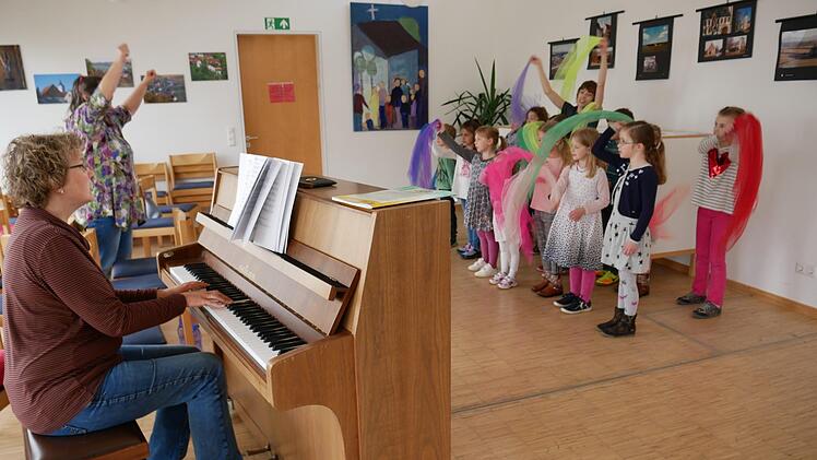 Annemarie Kreuzer begleitet die Chorsängerinnen und -sänger am Klavier, Petra Rohracker gibt im Hintergrund die Bewegungen vor.  Foto: Heike Beudert