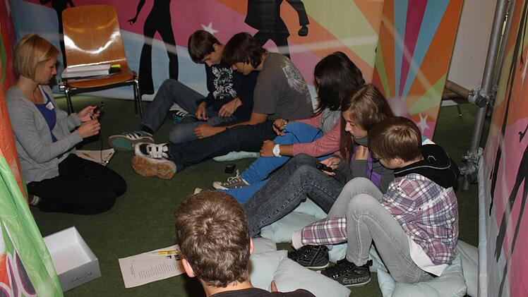 Mit Coach Claudia Naumann (links) suchen Schüler in Liedern nach Zeilen über Alkoholkonsum.  Foto: may