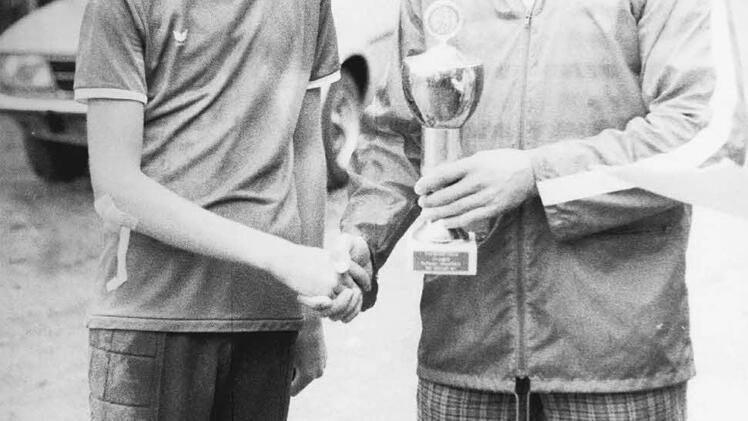 Die Siegerehrung beim Raiffeisen-Pokal der C-Jugend nimmt Bad Bocklets Organisationsleiter Gerhard Warmuth vor und überreicht den Pokal an den Spielführer des FC Hammelburg, Mathias Förster.