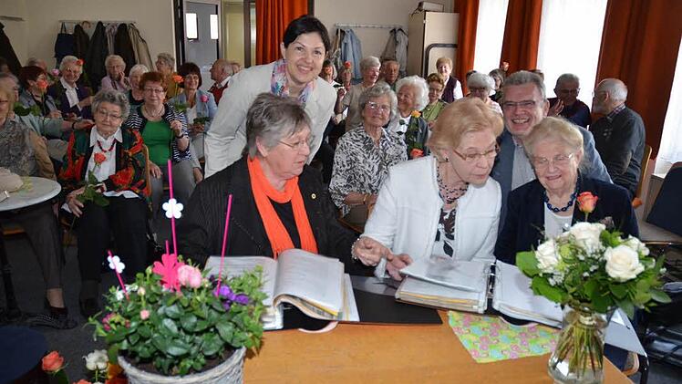 Ordner, in denen alle Veranstaltungen und Programme von 35 Jahren festgehalten wurden, fanden großes Interesse. Erklärungen gaben dazu, (vorne, von links): Elke Grötzner, Anneliese Geyer und Anna Beate Förtsch, dahinter Angela Hofmann und VHS-Leiter Heinz Tischler. Jeder Teilnehmer wurde mit einer Rose beschenkt.