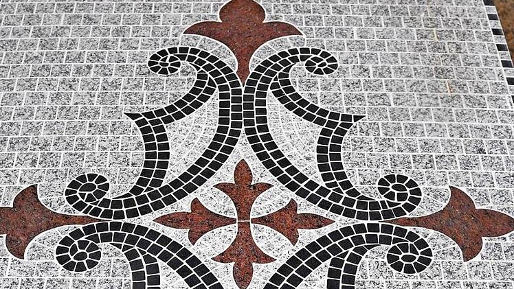 Wilhelm Dorsch zeigt alte Mosaik-Vorlagen, nach denen schon Firmengründer Umberto Revelant gearbeitet hat (oben links), und Wolfgang Dorsch eine der beiden alten Schleifmaschinen, die die Familie aus dem Freilandmuseum in Bad Windsheim zurückgeholt hat (unten links).  Fotos: Ronald Rinklef
