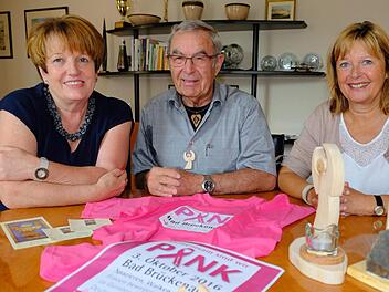 Kleine Holzengel (vorn rechts) schnitzt Kurt Müller für den Pinklauf in Bad Brückenau. Bürgermeisterin Brigitte Meyerdierks (links) und Organisatorin Karin Bauer bedankten sich dafür. Foto: Gerd Schaar