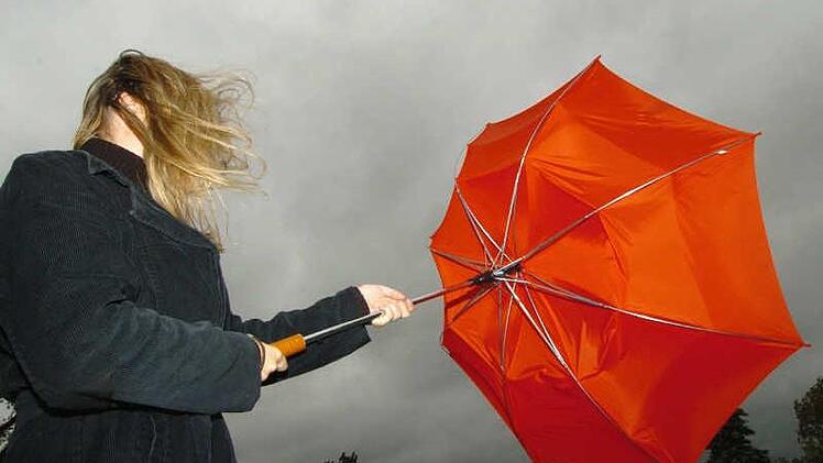 Ganz schön stürmisch: Eine junge Frau hält bei starkem Wind ihren Regenschirm festSymbolbild: Armin Weigel dpa/lby