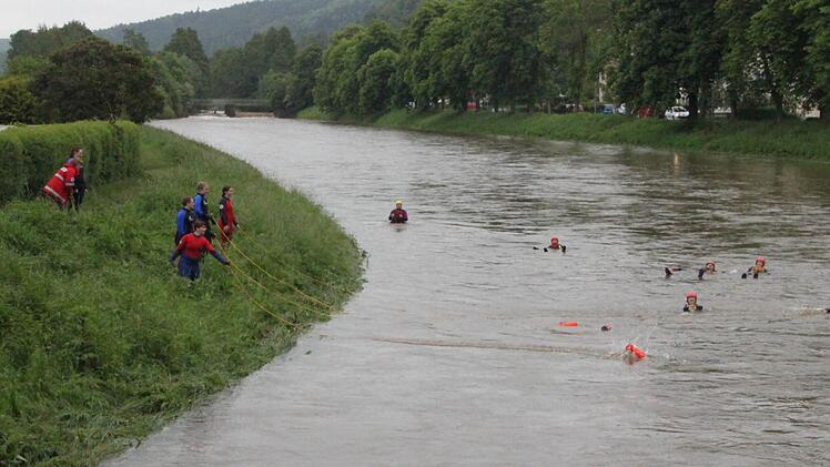 In der Strömung treiben hilflose Personen. Vom Ufer aus werfen ihnen die angehenden Wasserretter den so genannten Wurfretter zu: Wer sich daran festhält, kann - wenn auch mit einiger Mühe - an Land gezogen werden.