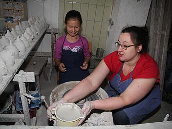 Die neunjährige Loreen Seiler darf Eva Potzel von der Töpferei Renner nicht nur über die Schulter schauen, sondern auch selbst an der Drehscheibe werkeln. Fotos: Sonja Adam