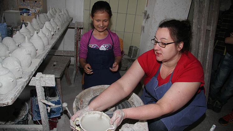 Die neunjährige Loreen Seiler darf Eva Potzel von der Töpferei Renner nicht nur über die Schulter schauen, sondern auch selbst an der Drehscheibe werkeln. Fotos: Sonja Adam