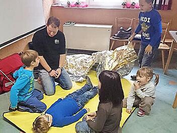 Spielerisch, aber dennoch praxisnah vermittelte Heiko Rödel den Mädchen und Jungen der Kupferberger Kinderfeuerwehr das Wissen in Erster Hilfe. Foto: Klaus-Peter Wulf
