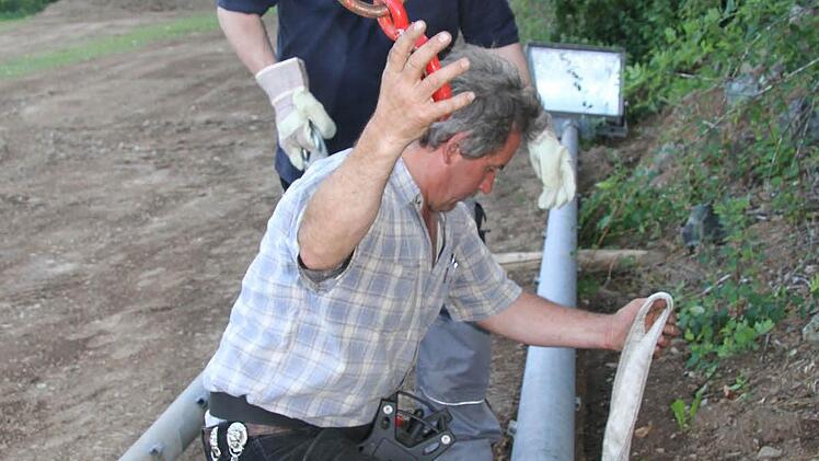 Horst Zeitler und Klaus Rödel hängen den Flutlichtmast an Gurte, damit er empor gehievt werden kann.