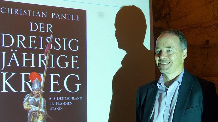 Christian Pantle vor einer Beamerpräsentation seines Buches Foto: Pauline Lindner
