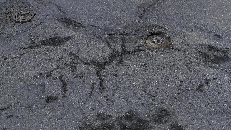 Kein Schlagloch, aber auch ein Ärgernis für Autofahrer und für Zweiradlenker nicht ungefährlich: halb versenkte Gulli- und Kanaldeckel.