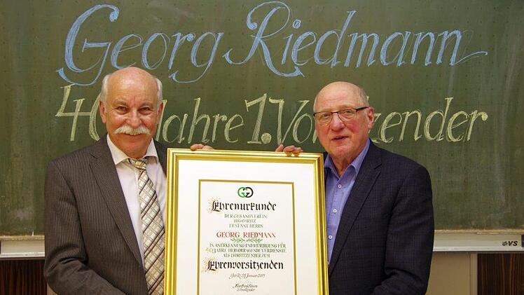 Manfred Simon (links) überreichte dem langjährigen Vorsitzenden Georg Riedmann die Urkunde des Garitzer Gesangvereins, mit der er zum Ehrenvorsitzenden ernannt wird. Klaus Werner