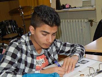 Abdul Basir müht sich um die richtige Schreibweise der eben gelernten Wörter. Foto: Helke Renner
