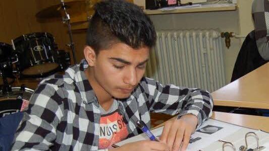 Abdul Basir müht sich um die richtige Schreibweise der eben gelernten Wörter. Foto: Helke Renner