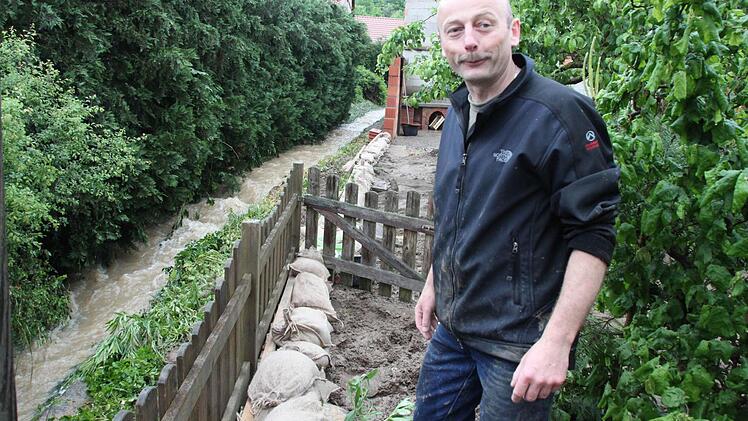 Thomas Erdmann zeigt den Wassergraben, der die Überschwemmung verursacht hat. Foto: Heike Beudert