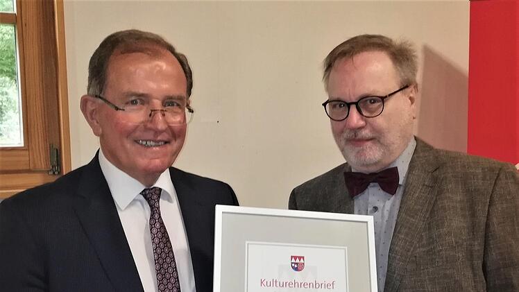 Bezirkstagspräsident Erwin Dotzel (links) verleiht den Kulturehrenbrief an den Schweinfurter Karnevalisten Peter Kuhn. Foto: Sigismund von Dobschütz