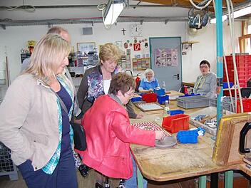 Mitarbeiter der Werkstkätten demonstrierten den Besuchern, wie Gummidichtungen für Bügelverschlussflaschen aufgedrückt werden. Foto: Welz