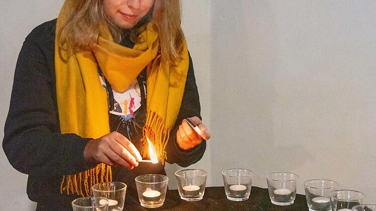 Ein Friedenslicht entzündet Mareike Naumann, aktives Mitglied im Jugendausschuss der Kirchengemeinde Michelau, am Taufstein.