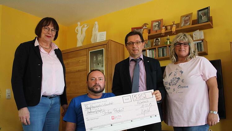 BR-Redaktionsleiter Alexander Müller und Veronika Specht von der Caritas überreichten Stefan Probst den Scheck. 5852 Euro waren über die Hilfsaktion "Franken helfen Franken" zusammengekommen. Rechts Ehefrau Beate Probst.