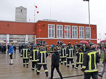 Der Regen konnte die gute Stimmung nicht trüben: Die stolzen Feuerwehrleute ziehen in ihr neues Zuhause. Foto: Johannes Michel