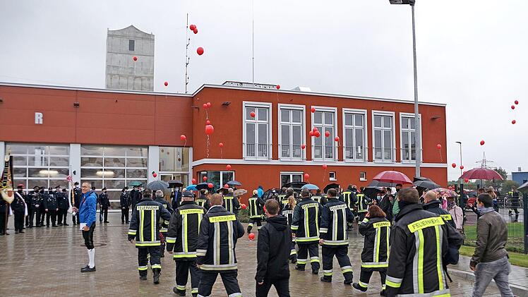 Der Regen konnte die gute Stimmung nicht trüben: Die stolzen Feuerwehrleute ziehen in ihr neues Zuhause. Foto: Johannes Michel