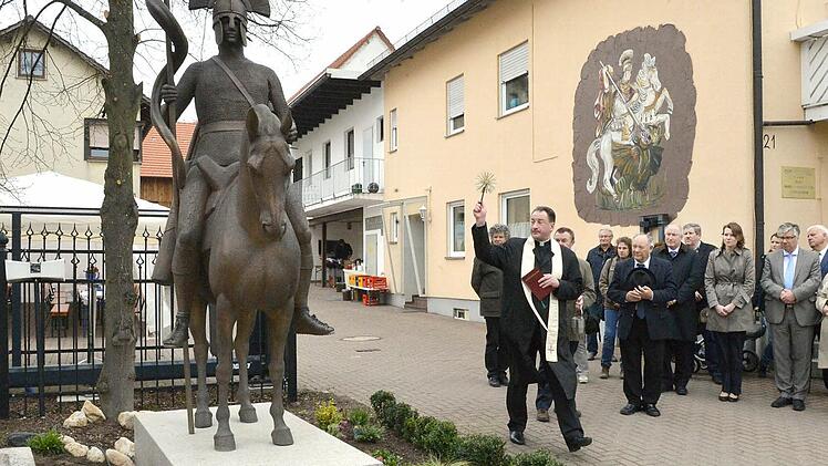 Monsignore Feulner bei der Weihe des Reiterstandbildes. Rechts daneben Georg Pfister und ein Teil der Gäste.  Foto: Ronald Rinklef